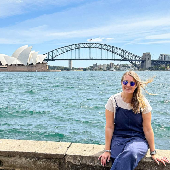 Charlie sat in Sydney with the Harbour Bridge behind her, ready to embark on her epic trip as she takes a career break in her 30's