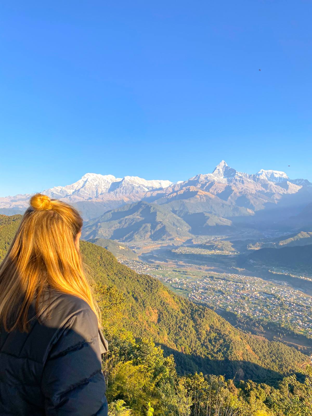 Charlie with her back to the camera, overlooking the mountains of Nepal, ready to embark on her epic trip as she takes a career break in her 30's
